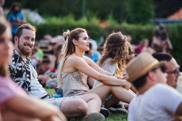 people at music festival sitting on grass