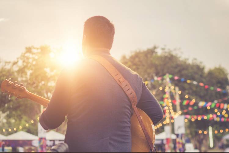 person playing guitar on stage at concert